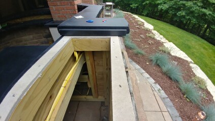 To install a pop-up style of TV lift in an outdoor bar, the author devised a simple gutter (shown here at one end where the concrete counter ends at the opening for the TV and pop-up assembly) to channel water away from the assembly.