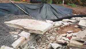 Three 6-foot-long stone slabs were cantilevered about 18 inches out from the wall at roughly 18 inches above finished grade to create informal seating. The weight of the stones, the backfill material, and the wall above the slabs will help hold them securely in place.