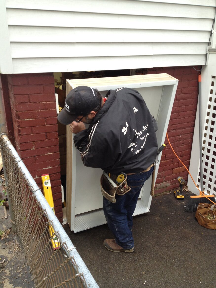 The custom pre-hung door slips in between the PVC blocks. Because the foundation was out of plumb and leaned in at the top, the tops of the door jambs were flushed with the brick, leaving the unit inset slightly at the bottom.